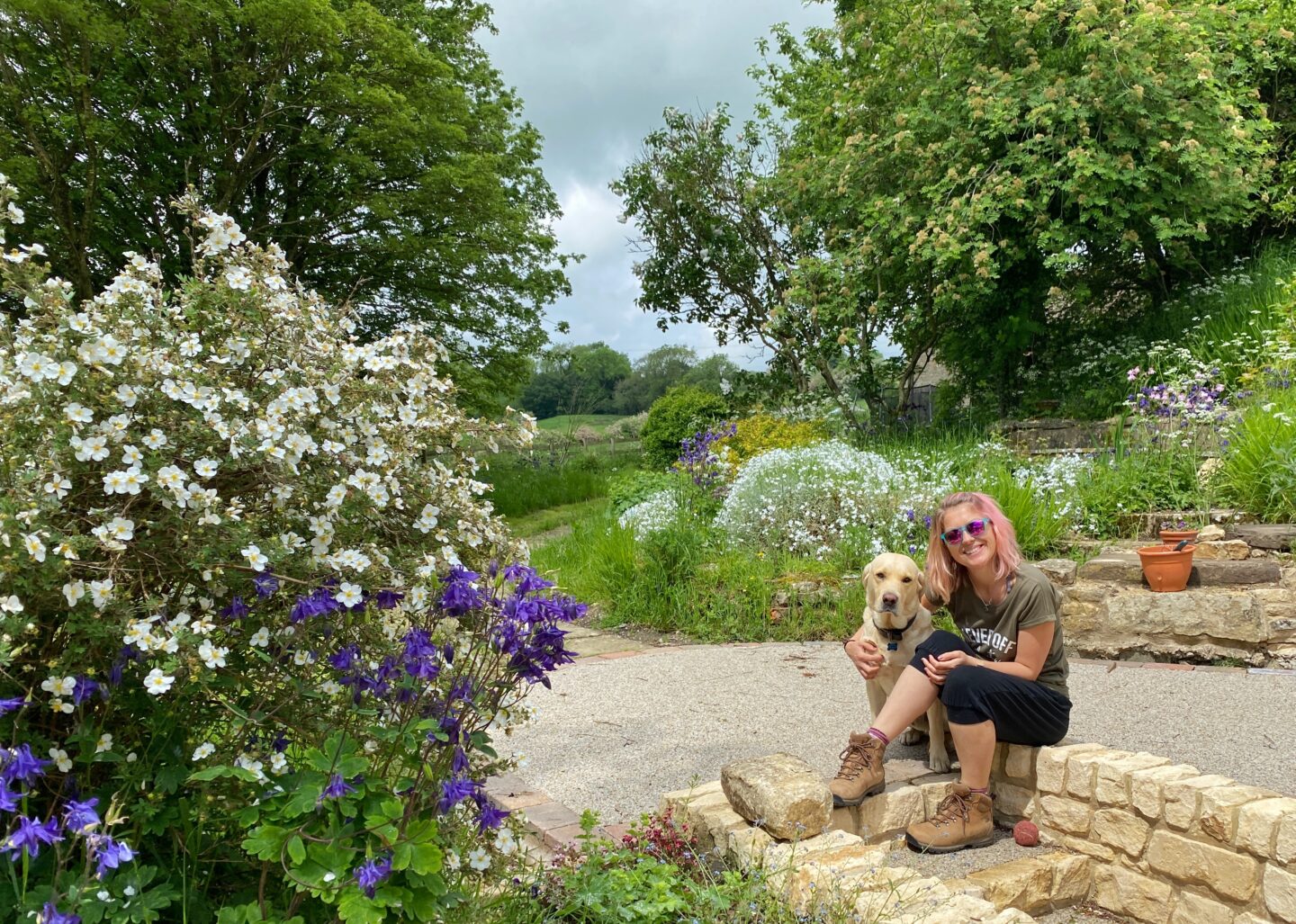 Myself and my dog sitting on the top step of a beautiful garden for a post about joint supplement antinol.