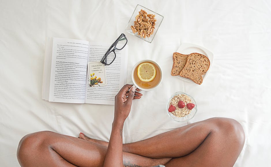legs of a woman, a book and food