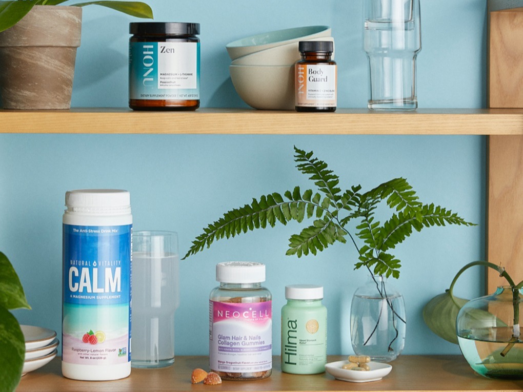 Image of plants and several vitamin products on two shelves including Calm gummies
